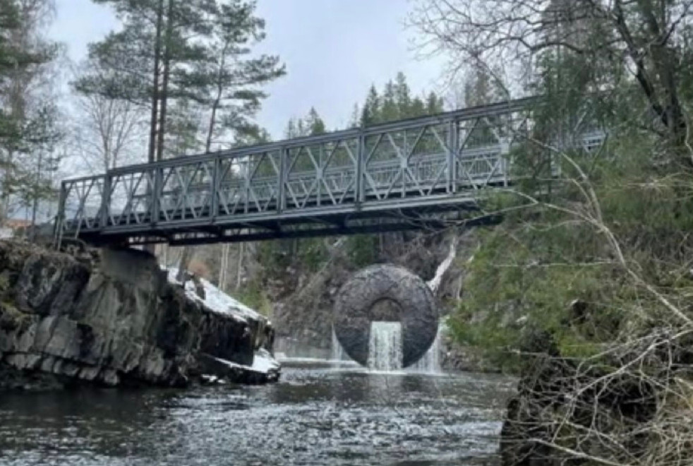 Kistefos gamle bru, sett over elven med den ikoniske vannskulpturen under. Foto.